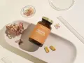 Suplement Omega-3 z DHA dla kobiet w ciąży, wspierający rozwój mózgu dziecka. Delikatne kapsułki na białej tacy z suszonymi kwiatami.