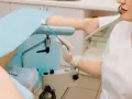 Lekarz przygotowuje się do pobrania wymazu do gbs badanie. Pacjentka leży na fotelu ginekologicznym.