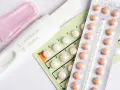 Test ciążowy i opakowania tabletek antykoncepcyjnych. Decyzja o odstawieniu tabletek antykoncepcyjnych może być trudna.