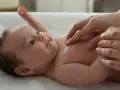 Delikatna pielęgnacja 3 miesięcznego dziecka. Krem na jego klatce piersiowej.
