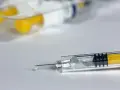 Strzykawka z kropelką leku, gotowa do podania. Heparyna w ciąży to często stosowane rozwiązanie.