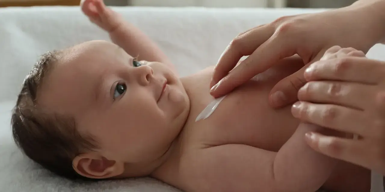 Delikatna pielęgnacja 3 miesięcznego dziecka. Krem na jego klatce piersiowej.