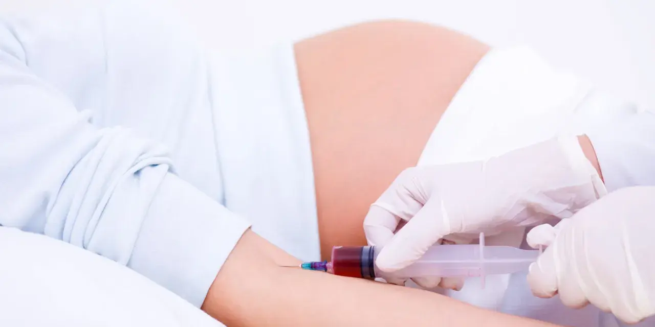 Pobieranie krwi do badań w 15 tygodniu ciąży. Lekarz w rękawiczkach pobiera krew strzykawką od ciężarnej.