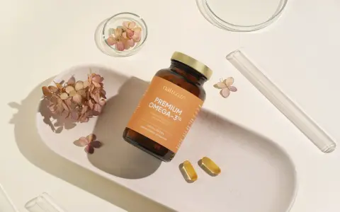 Suplement Omega-3 z DHA dla kobiet w ciąży, wspierający rozwój mózgu dziecka. Delikatne kapsułki na białej tacy z suszonymi kwiatami.
