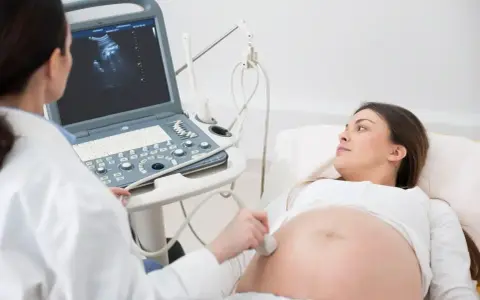 Lekarz wykonuje badanie USG, sprawdzając obrót zewnętrzny płodu u ciężarnej kobiety.