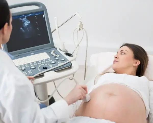 Lekarz wykonuje badanie USG, sprawdzając obrót zewnętrzny płodu u ciężarnej kobiety.