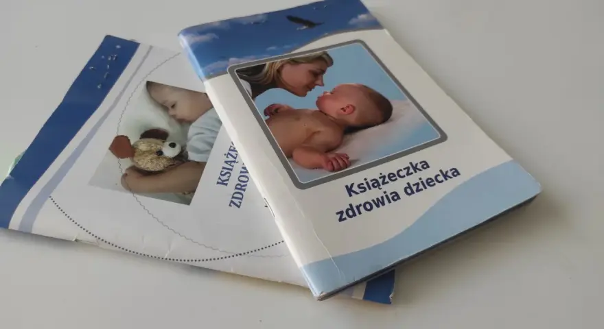 Książeczka zdrowia dziecka, ważna dla szczepienia 5 latka. Na okładce mama z niemowlakiem i śpiący maluch z misiem.