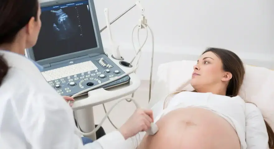 Lekarz wykonuje badanie USG, sprawdzając obrót zewnętrzny płodu u ciężarnej kobiety.