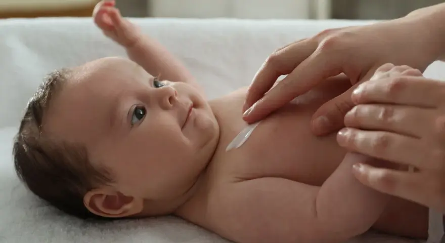 Delikatna pielęgnacja 3 miesięcznego dziecka. Krem na jego klatce piersiowej.